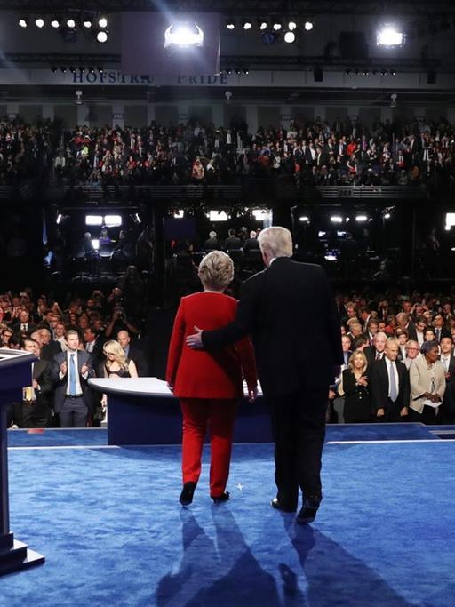 Hillary Clinton und Donald Trump am Ende der ersten Fernsehdebatte, sie stehen mit dem Rücken zur Kamera.