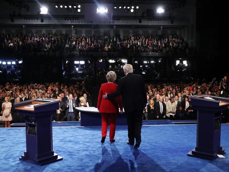 Hillary Clinton und Donald Trump am Ende der ersten Fernsehdebatte, sie stehen mit dem Rücken zur Kamera.