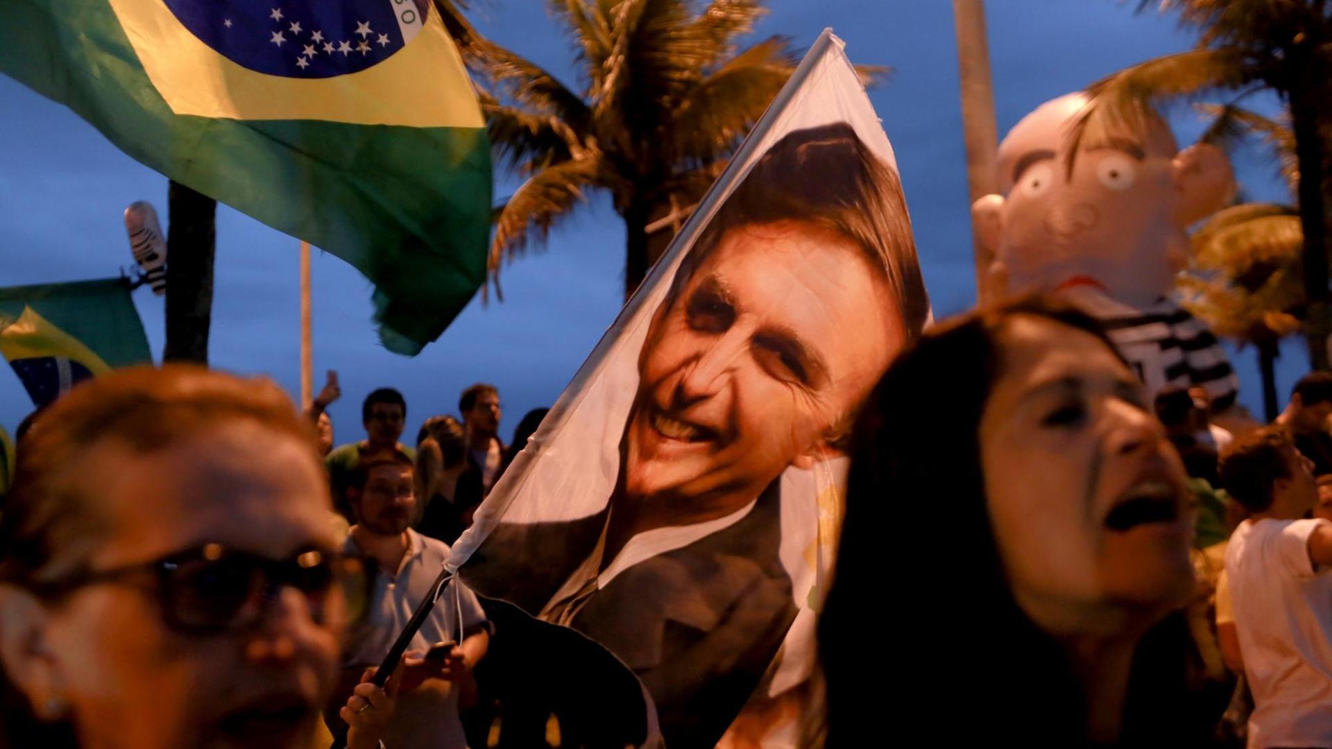 07.10.2018, Brasilien, Rio de Janeiro: Unterstützer des rechtspopulistischen Kandidaten bei der Präsidentenwahl, Bolsonaro, jubeln während der Wahlen und warten auf die Wahlergebnise. 07.10.2018, Brasilien, Rio de Janeiro: Unterstützer des rechtspopulistischen Kandidaten bei der Präsidentenwahl, Bolsonaro, jubeln während der Wahlen und warten auf die Wahlergebnise.