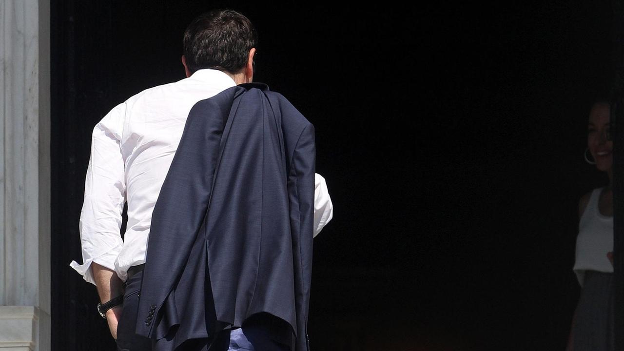 Alexis Tsipras kehrt in Athen in sein Büro zurück. Man sieht ihn von hinten, seine Jacke hängt über der Schulter. Alexis Tsipras kehrt in Athen in sein Büro zurück. Man sieht ihn von hinten, seine Jacke hängt über der Schulter.