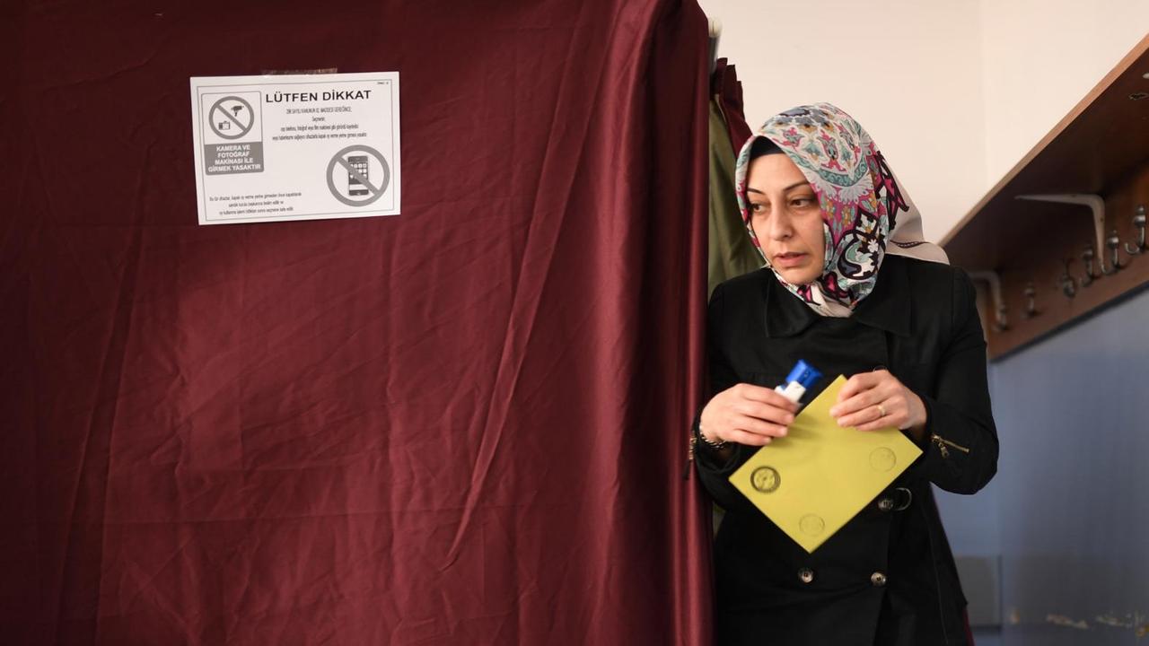 Eine Frau kommt in Istanbul aus einer Wahlkabine.