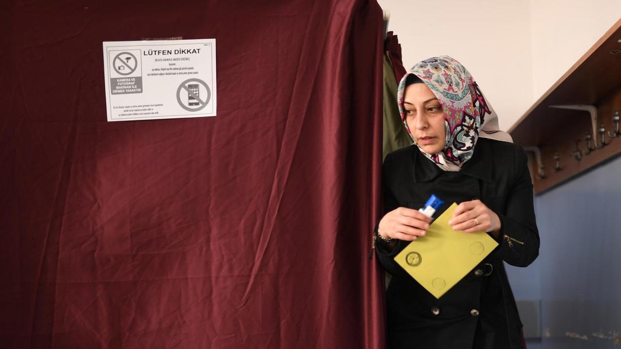 Eine Frau kommt in Istanbul aus einer Wahlkabine. Eine Frau kommt in Istanbul aus einer Wahlkabine.
