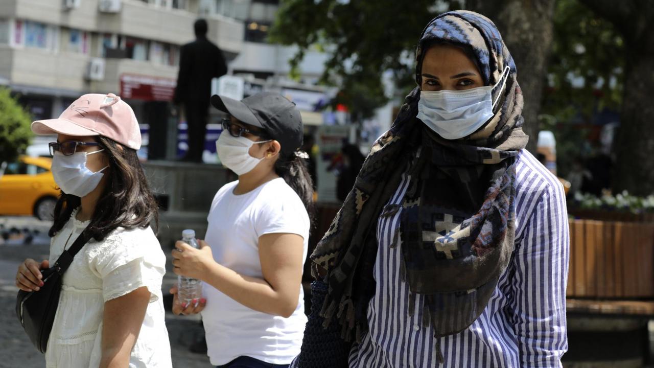 Ankara: Eine türkische Frau und Kinder tragen Mundschutz bei einem Spaziergang in einem öffentlichen Garten. 