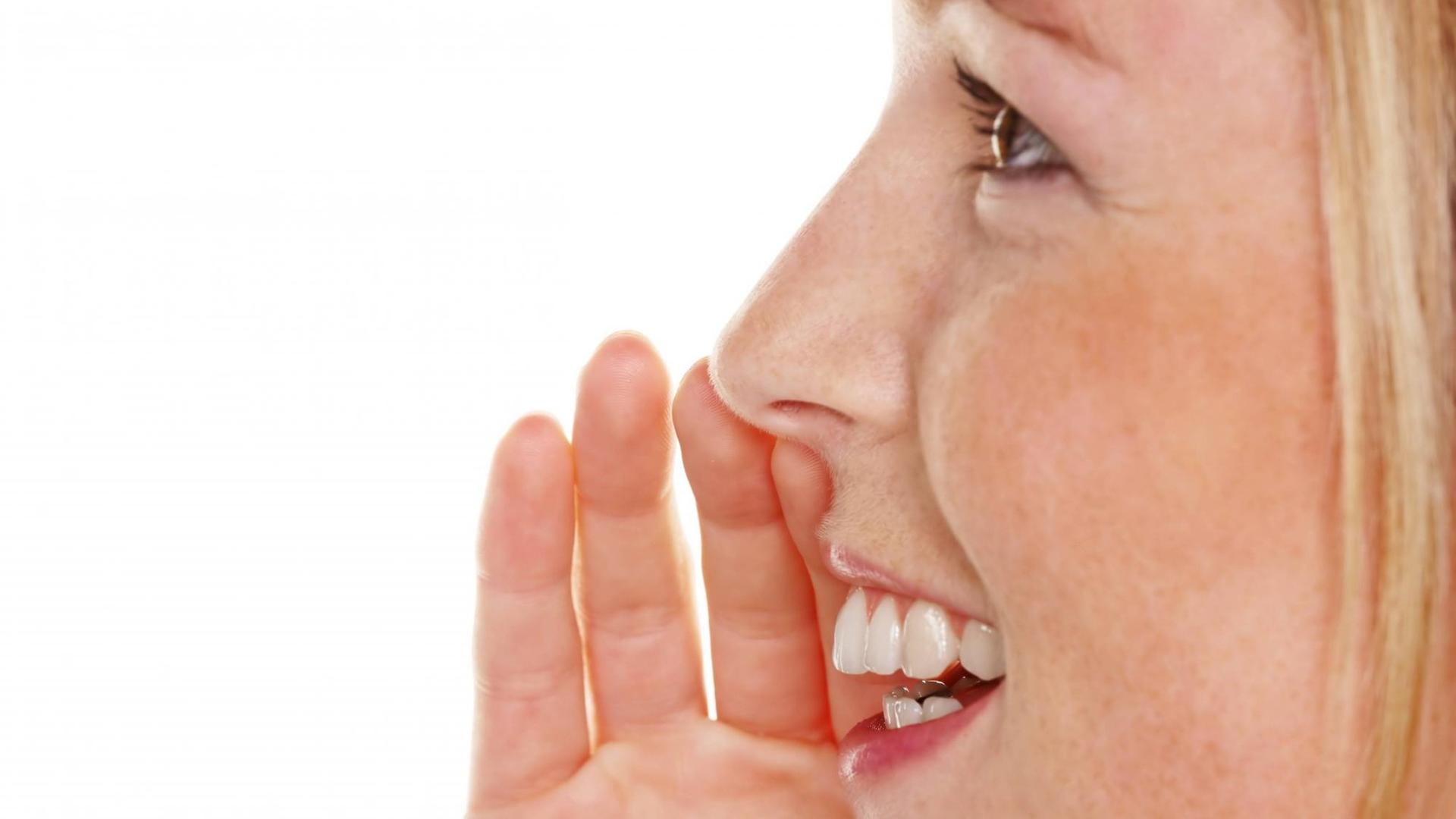 Eine junge Frau spricht und hält dabei die Hand an das Gesicht. Eine junge Frau spricht und hält dabei die Hand an das Gesicht.