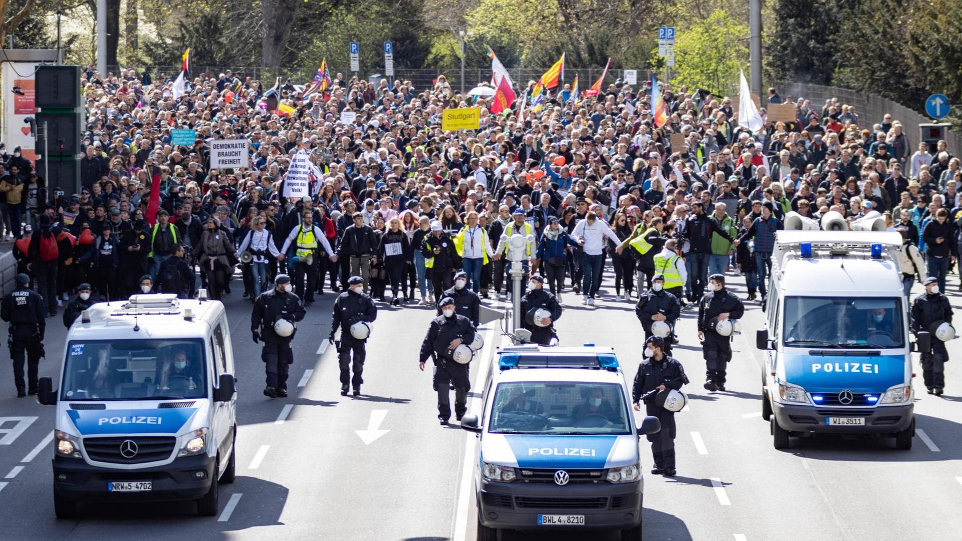 Demonstration von "Querdenken 711" in Stuttgart am Karsamstag. Vor der Demo sind Polizeifahrzeuge zu sehen.