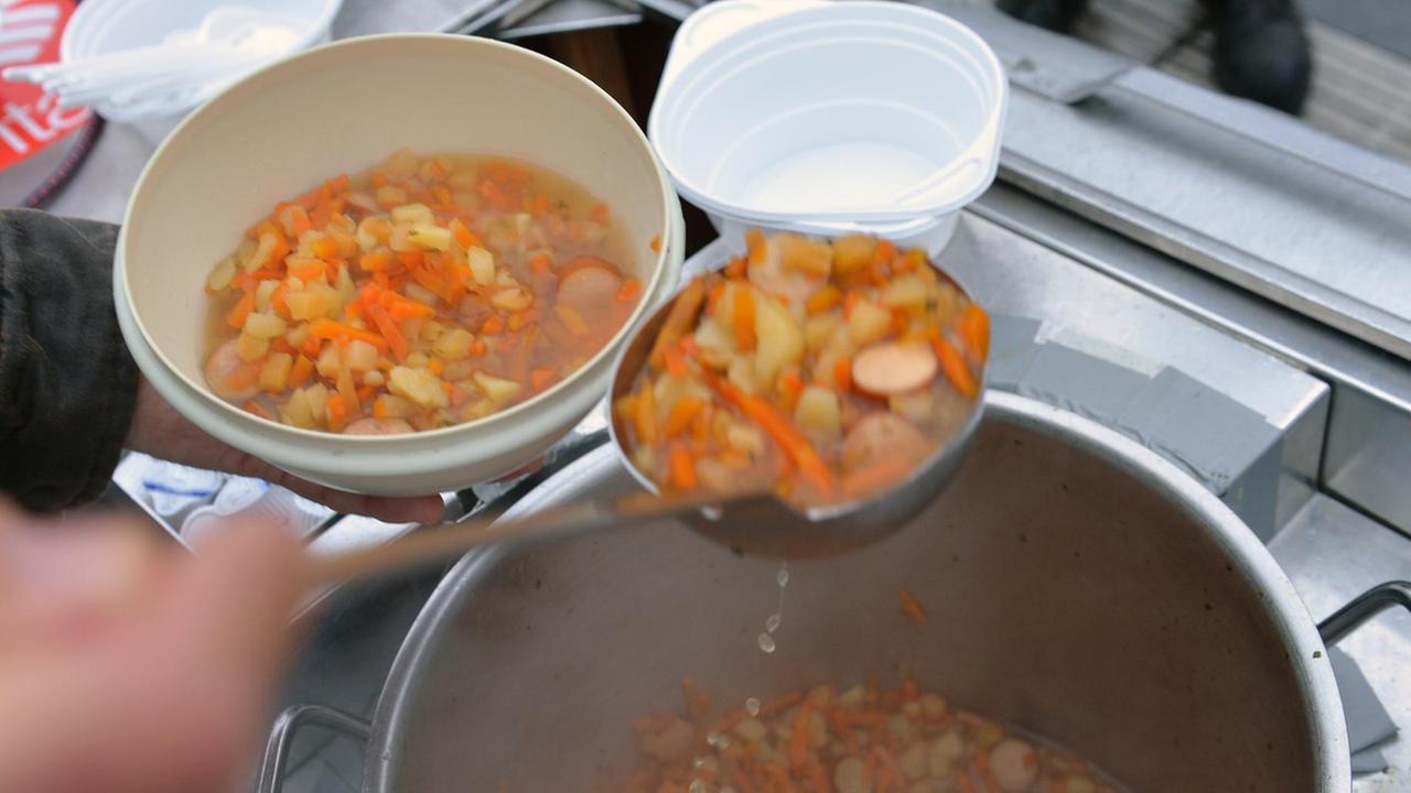 Gerolf Wortmann, Ehrenamtlicher Helfer der Caritas, füllt am 19.11.2013 vor dem Bahnhof in Bremen Suppe in einen Teller. Gerolf Wortmann, Ehrenamtlicher Helfer der Caritas, füllt am 19.11.2013 vor dem Bahnhof in Bremen Suppe in einen Teller.