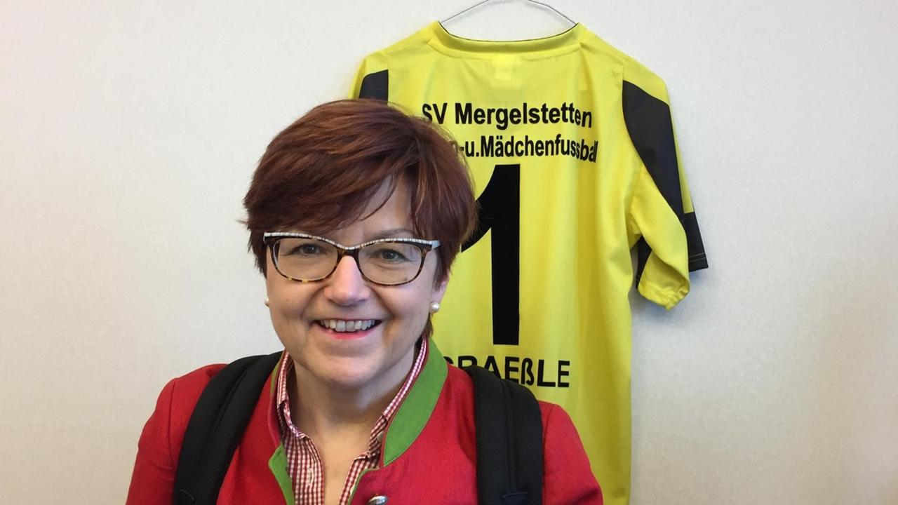 Die CDU-Europaabgeordnete Ingeborg Gräßle steht vor einer Wand, an der ein Trikot mit der Nummer Eins, ihrem Namen und Mädchenfußball hängt Die CDU-Europaabgeordnete Ingeborg Gräßle steht vor einer Wand, an der ein Trikot mit der Nummer Eins, ihrem Namen und Mädchenfußball hängt