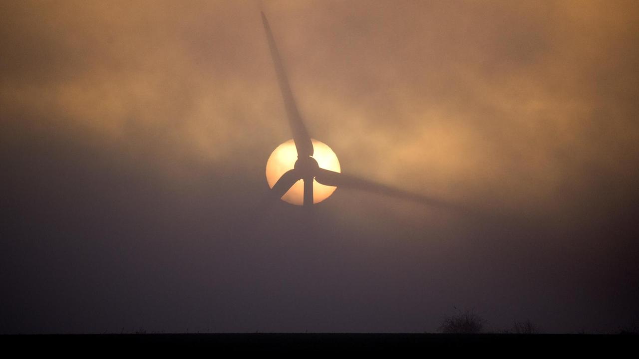Bei Sehnde in Niedersachsen geht die Sonne hinter einem Windrad inmitten von Nebelschwaden auf Bei Sehnde in Niedersachsen geht die Sonne hinter einem Windrad inmitten von Nebelschwaden auf