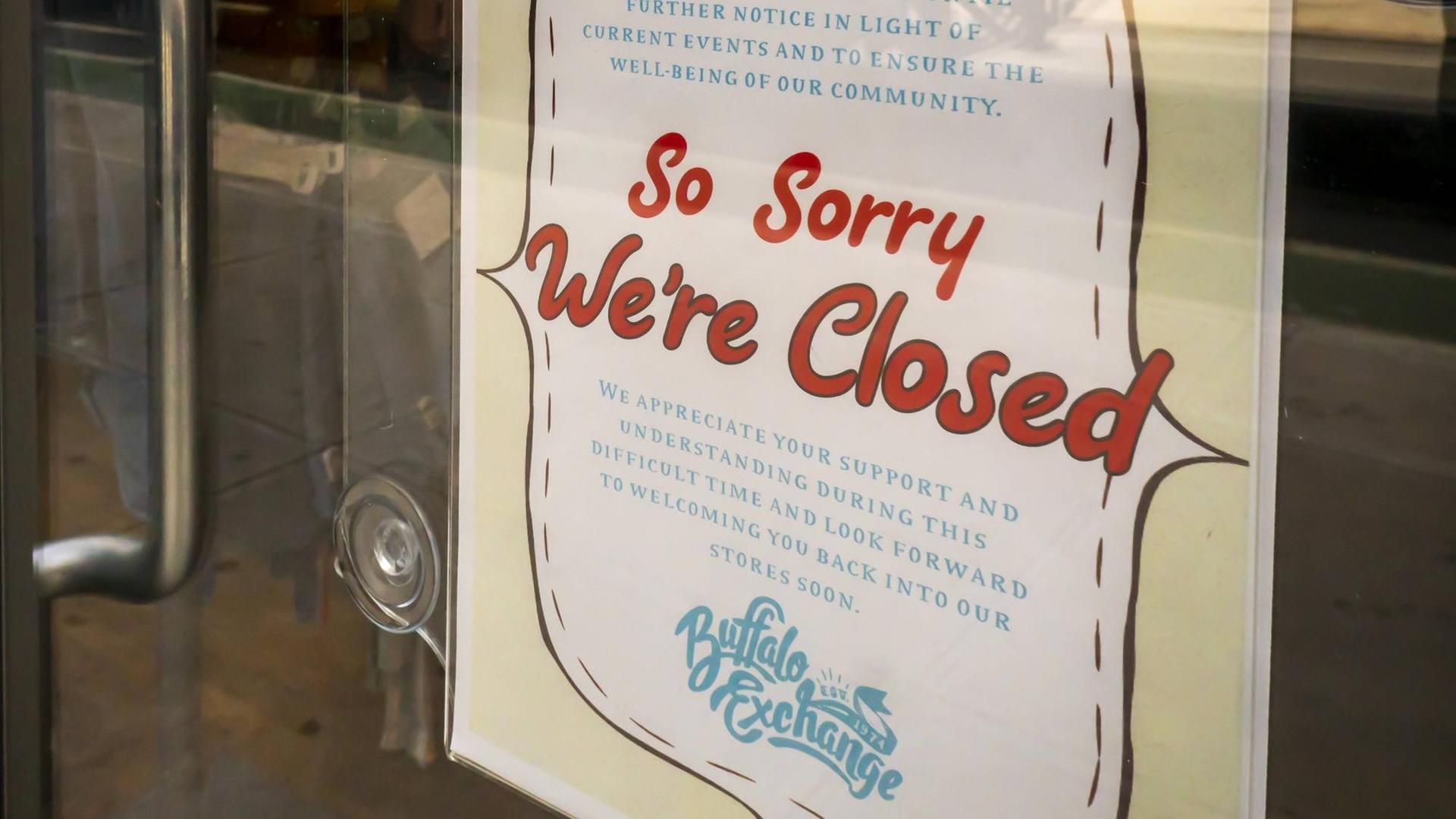 Ein Schild mit der Aufschrift "So sorry we're closed" hängt an der Tür einer Filiale der Second-Hand-Modekette "Buffalo Exchange" in New York. Ein Schild mit der Aufschrift "So sorry we're closed" hängt an der Tür einer Filiale der Second-Hand-Modekette "Buffalo Exchange" in New York.