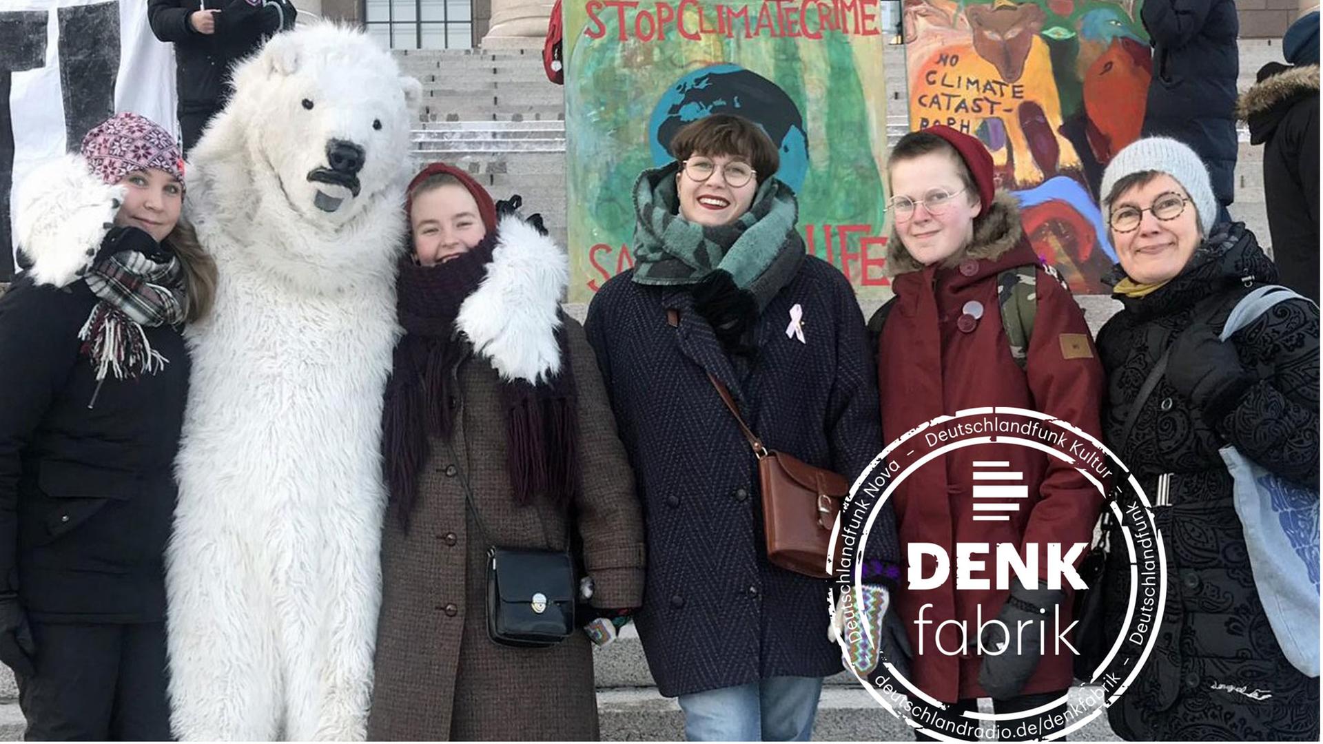 Klimaschutz-Demonstranten vor dem finnischen Parlament in Helsinki, einer trägt ein Eisbärenkostüm.