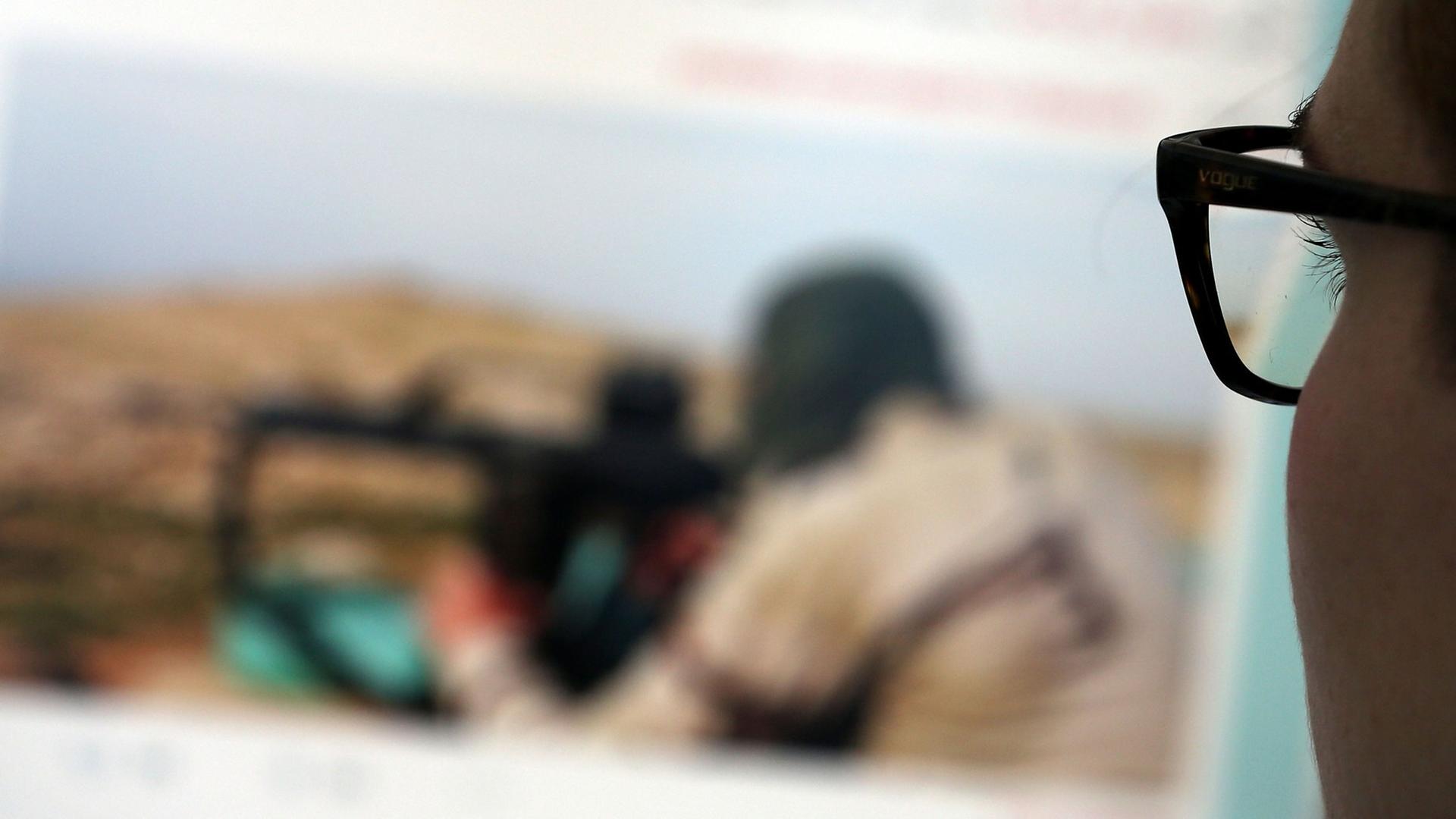Eine Frau schaut auf eine Website mit Propaganda des IS. Eine Frau schaut auf eine Website mit Propaganda des IS.