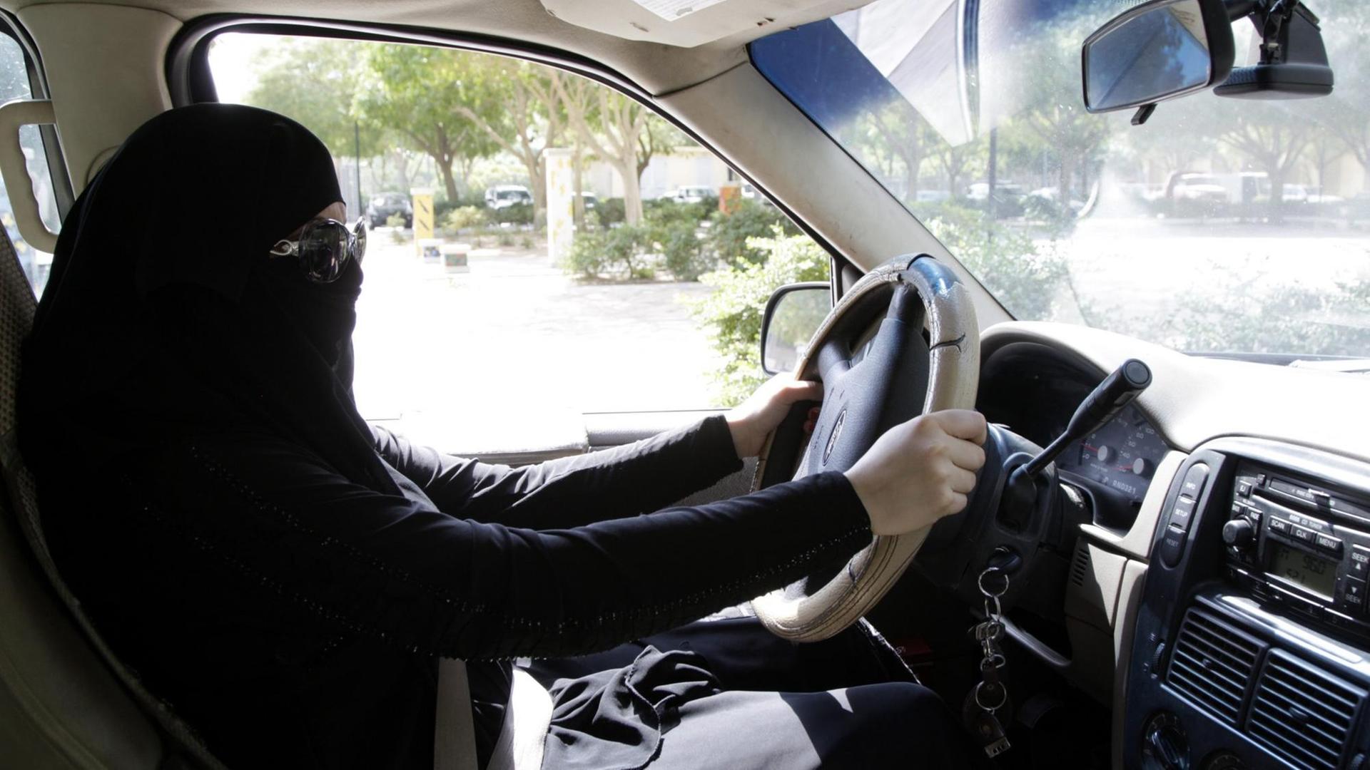 Eine saudische Frau sitzt hinter dem Lenkrad eines Autos in Riad, Saudi-Arabien 