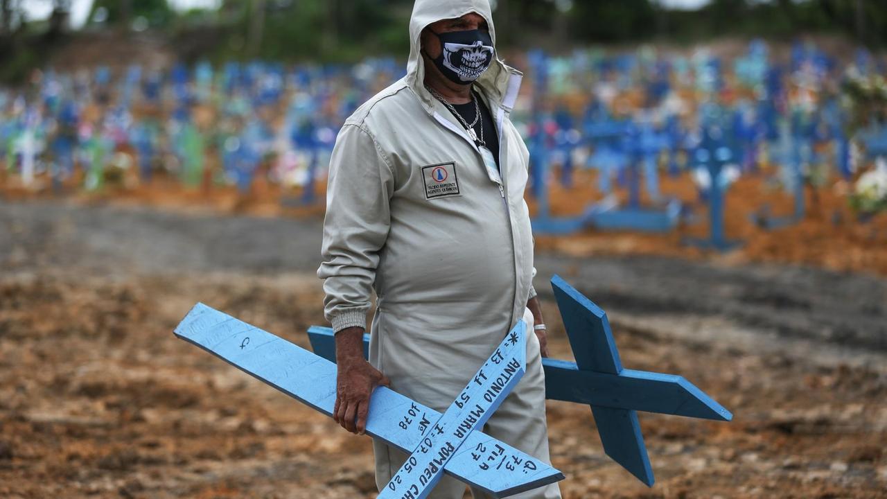 Ein Friedhofsmitarbeiter in Manaus, Brasilien, mit Kreuzen für neue Gräber. Ein Friedhofsmitarbeiter in Manaus, Brasilien, mit Kreuzen für neue Gräber.