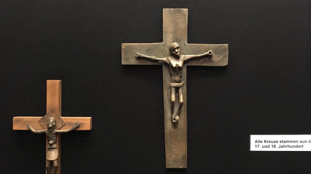 Im Haus Völker und Kulturen ausgestellte afrikanische Kruzifixe - im Zentrum eines mit weiblichem Christus Im Haus Völker und Kulturen ausgestellte afrikanische Kruzifixe - im Zentrum eines mit weiblichem Christus