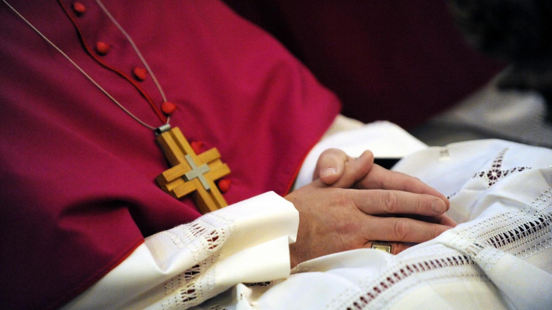 Ein Bischof hat die Hände in den Schoß gelegt und nimmt am Gottesdienst teil. Ein Bischof hat die Hände in den Schoß gelegt und nimmt am Gottesdienst teil.