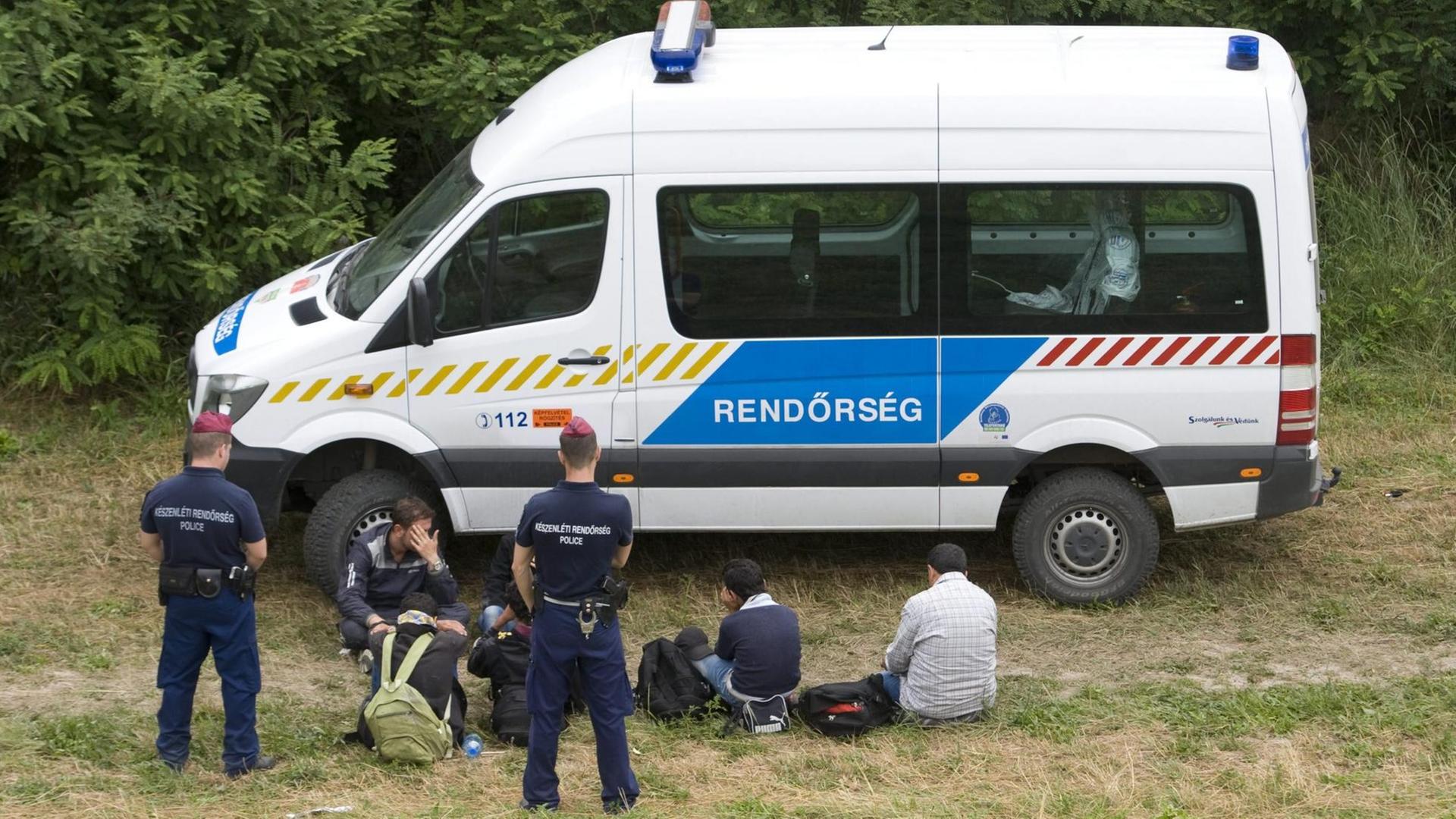 Flüchtlinge bei Szeged in Ungarn werden von der Polizei festgenommen.
