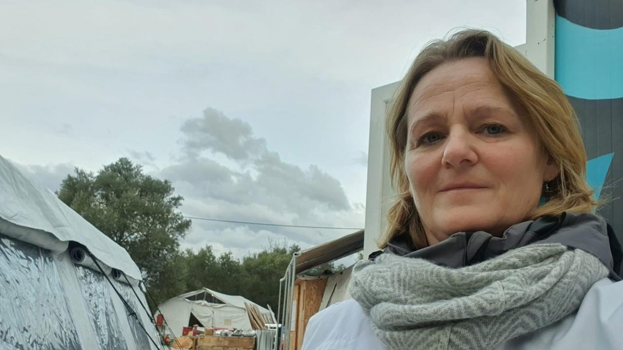 Eine blonde Frau mittleren Alters mit Schal und schulterlangen blonden Haaren. Eine blonde Frau mittleren Alters mit Schal und schulterlangen blonden Haaren.