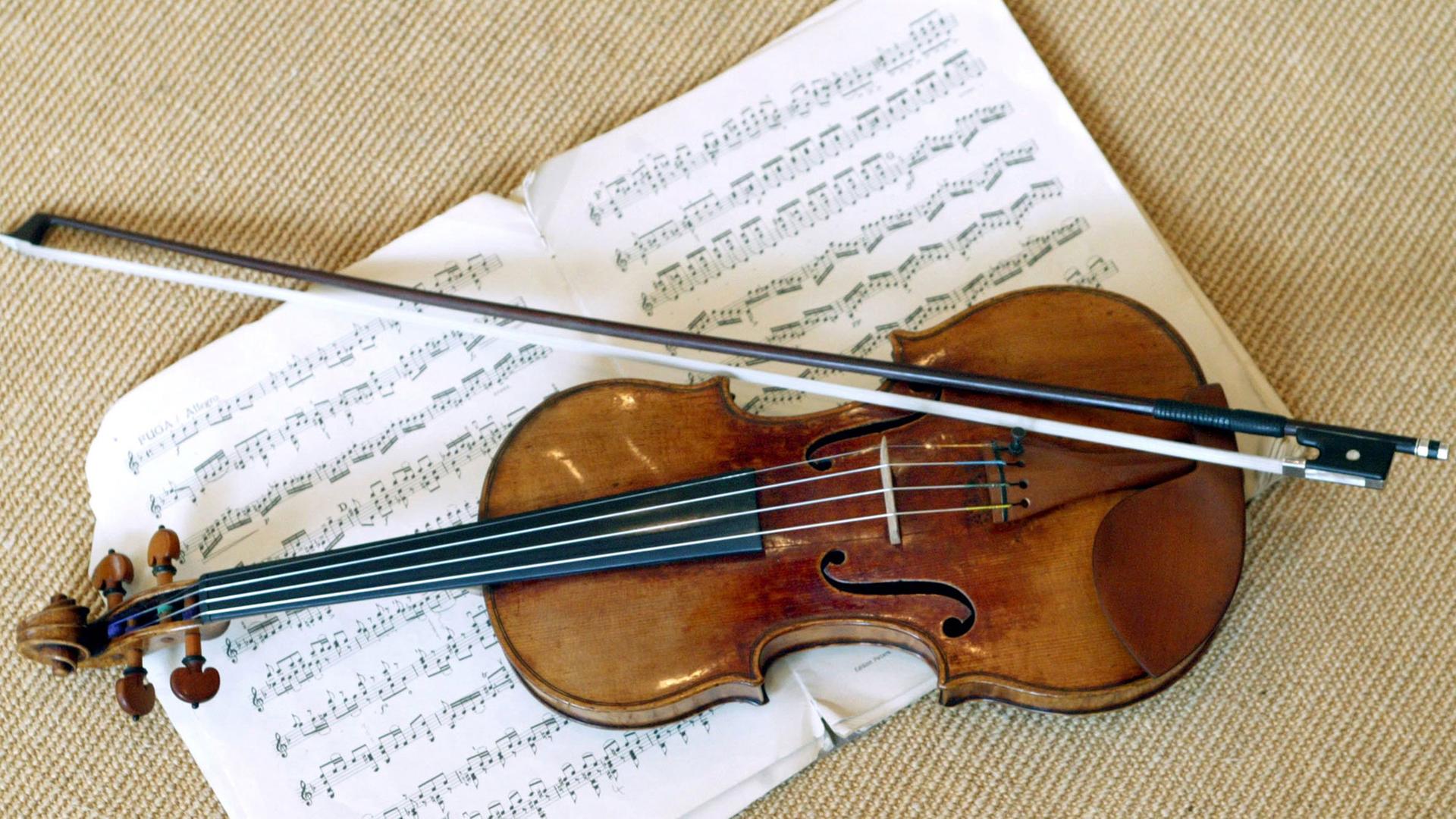 Eine Stradivari liegt mit einem Geigenbogen auf einem Notenblatt.