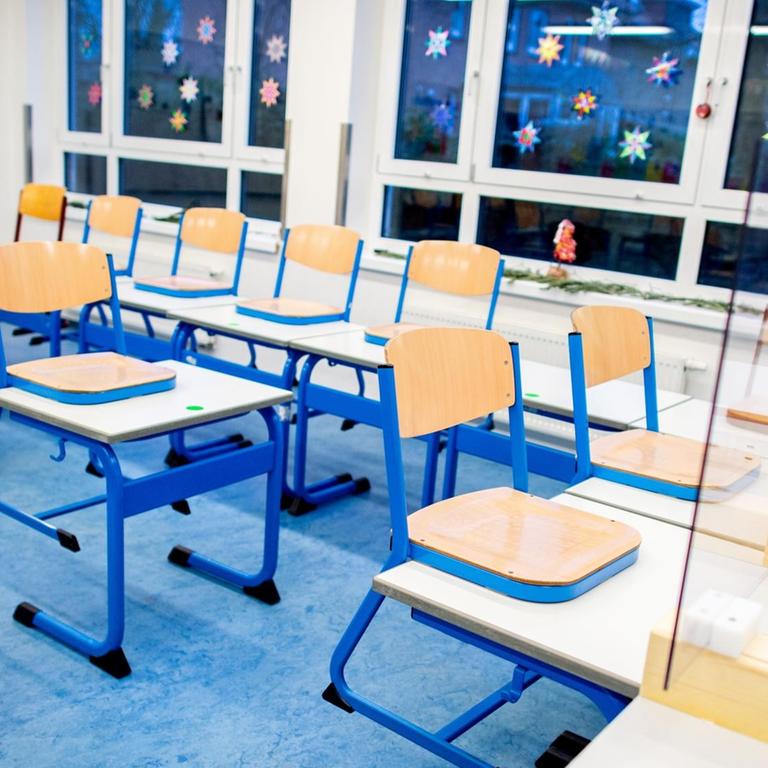 Stühle und Tische stehen in einem Klassenraum.