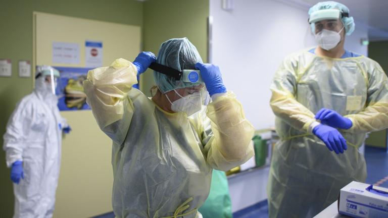 Stabsunteroffizierin Sophie Wasiliga (l) und Stabsfeldwebel Rene Kühn, Soldaten des Sanitätsdienstes der Bundeswehr Weißenfels aus Sachsen-Anhalt, kleiden sich auf der Corona-Station im Städtischen Klinikum mit Schutzkleidung ein. Stabsunteroffizierin Sophie Wasiliga (l) und Stabsfeldwebel Rene Kühn, Soldaten des Sanitätsdienstes der Bundeswehr Weißenfels aus Sachsen-Anhalt, kleiden sich auf der Corona-Station im Städtischen Klinikum mit Schutzkleidung ein.