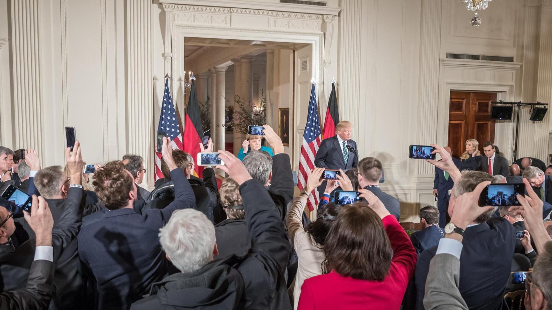 Journalisten fotografieren US-Präsident Donald Trump und Bundeskanzlerin Angela Merkel im Weißen Haus.