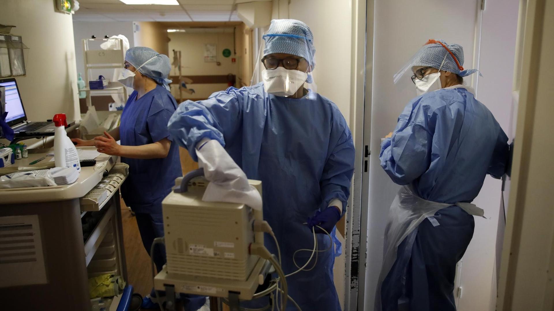 Medizinisches Personal in Schutzkleidung in einem Krankenhaus in Paris, in dem Covid-19-Patienten behandelt werden. Eine Person desinfiziert ein technisches Gerät. Medizinisches Personal in Schutzkleidung in einem Krankenhaus in Paris, in dem Covid-19-Patienten behandelt werden. Eine Person desinfiziert ein technisches Gerät.