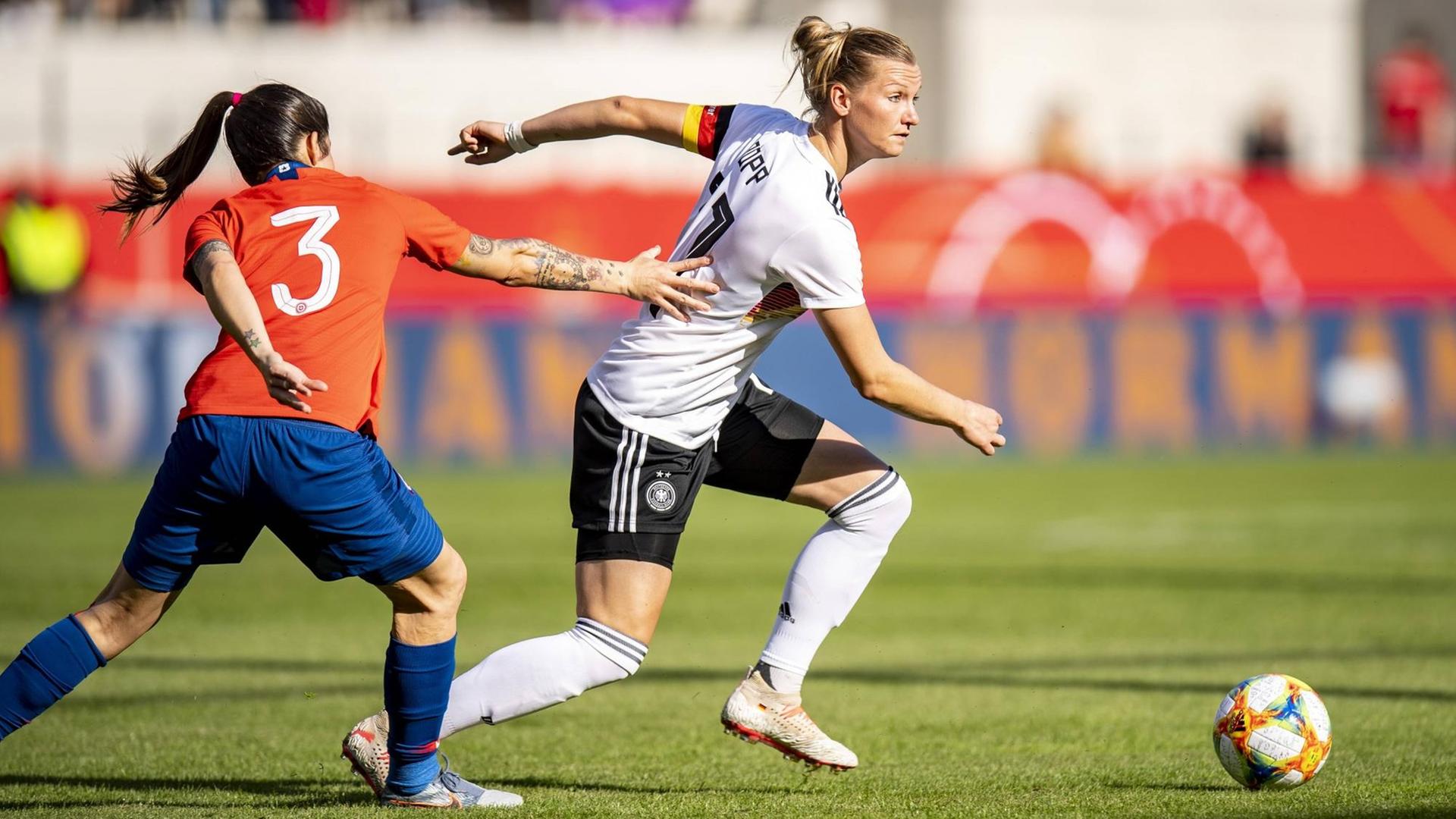 Die deutsche Fußballnationalspielerin Alexandra Popp läuft beim Testspiel gegen Chile mit dem Ball am Fuß an ihrer Gegenspielerin vorbei.
