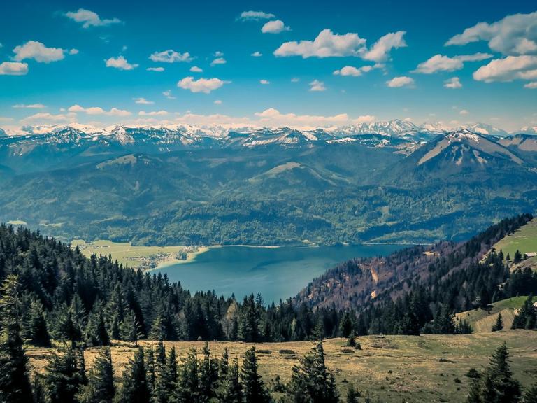 Der Blick fällt auf einen See, dessen blaue Tiefen von einer Bergkette umgeben sind.