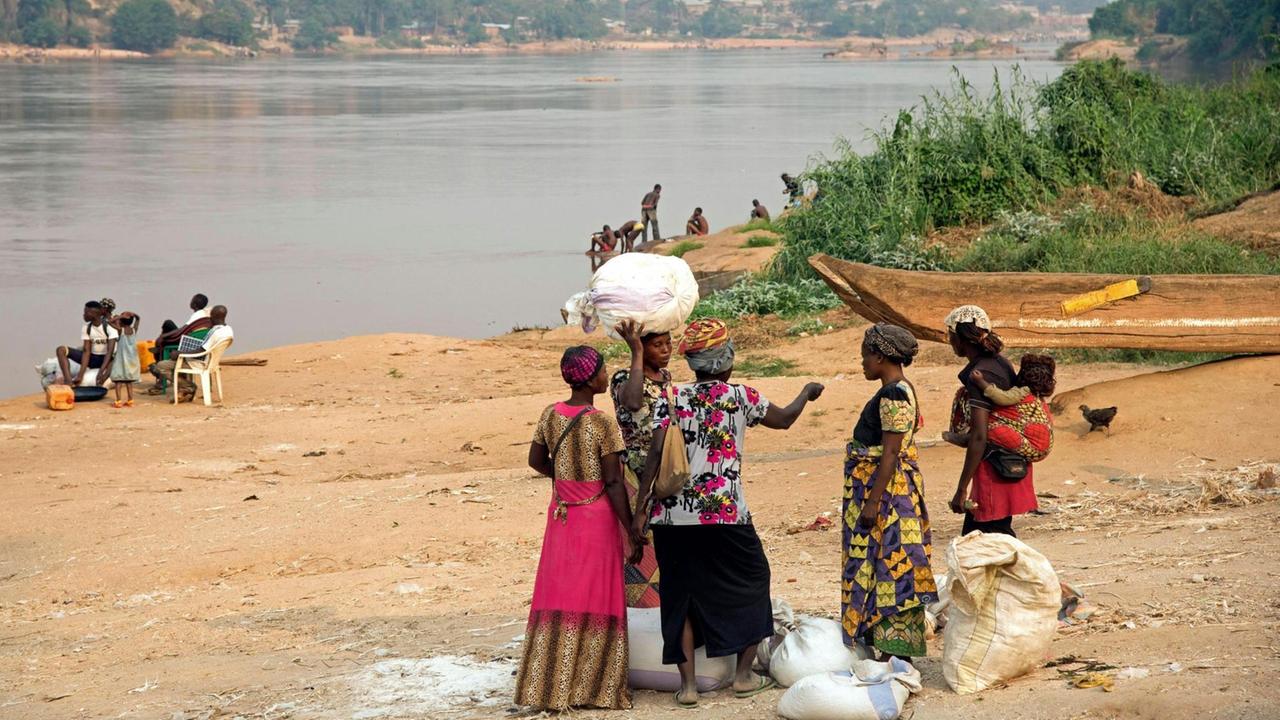 Menschen stehen am Fluss Kasai in der Demokratischen Republik Kongo