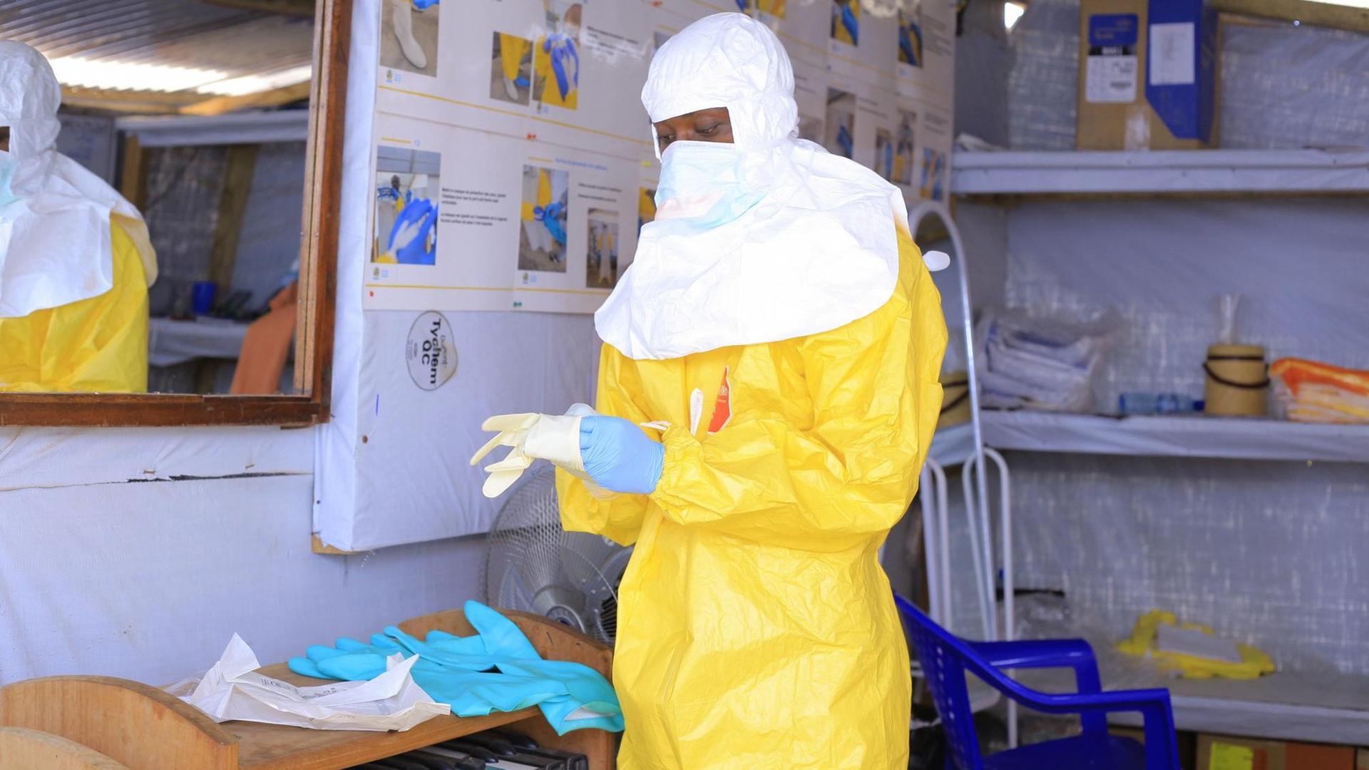 Eine Psychologin legt im Ebola-Behandlungszentrum CTE ALIMA BENI Schutzkleidung an. Seit einem Jahr wütet die Seuche Ebola im Osten des Kongos. Eine Psychologin legt im Ebola-Behandlungszentrum CTE ALIMA BENI Schutzkleidung an. Seit einem Jahr wütet die Seuche Ebola im Osten des Kongos.