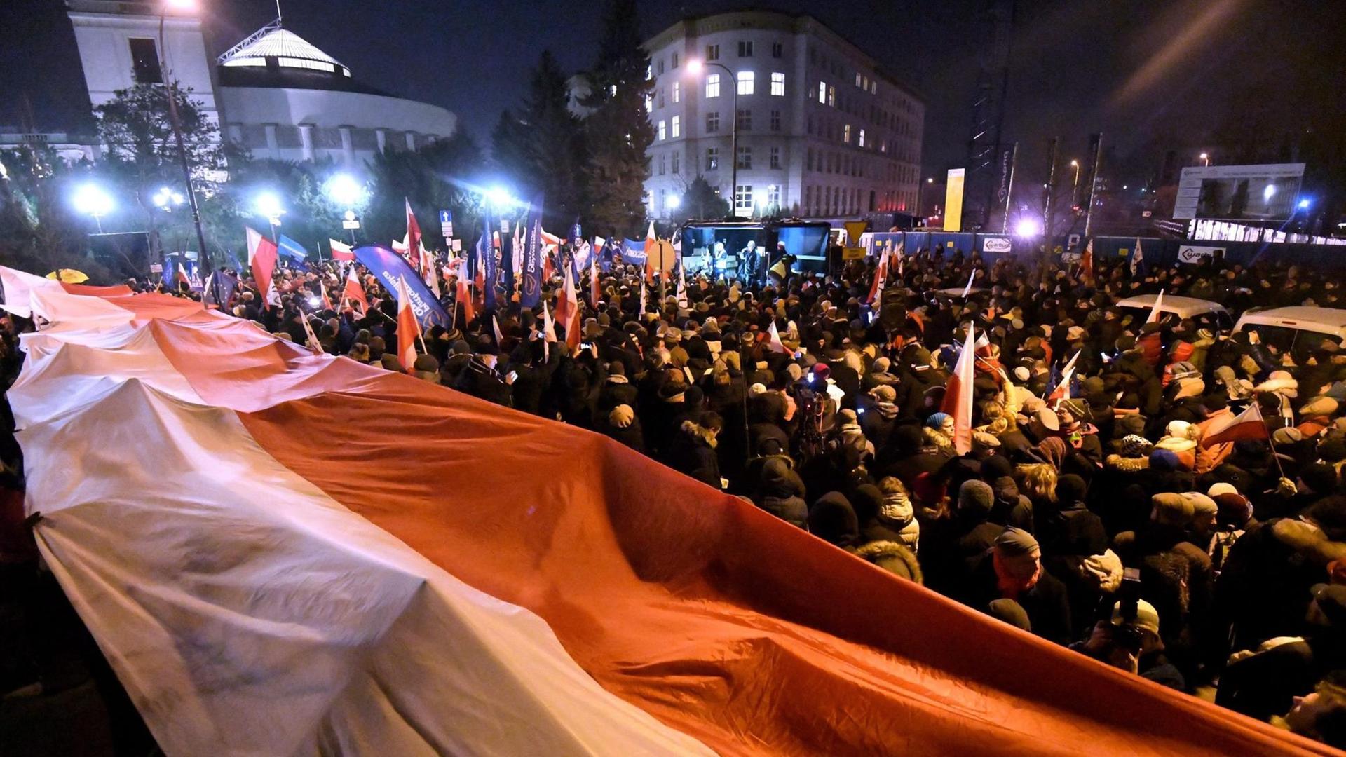Demonstranten in Polen tragen eine riesige polnische Fahne Demonstranten in Polen tragen eine riesige polnische Fahne
