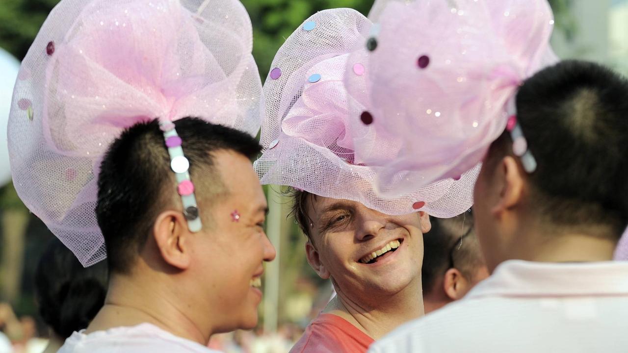 Homosexuelle Teilnehmer bei einer "Pink Dot" Demonstration in Singapur mit rosa Tüll auf dem Kopf, um die LGBT Bewegung zu unterstützen, Juni 2013. Homosexuelle Teilnehmer bei einer "Pink Dot" Demonstration in Singapur mit rosa Tüll auf dem Kopf, um die LGBT Bewegung zu unterstützen, Juni 2013.