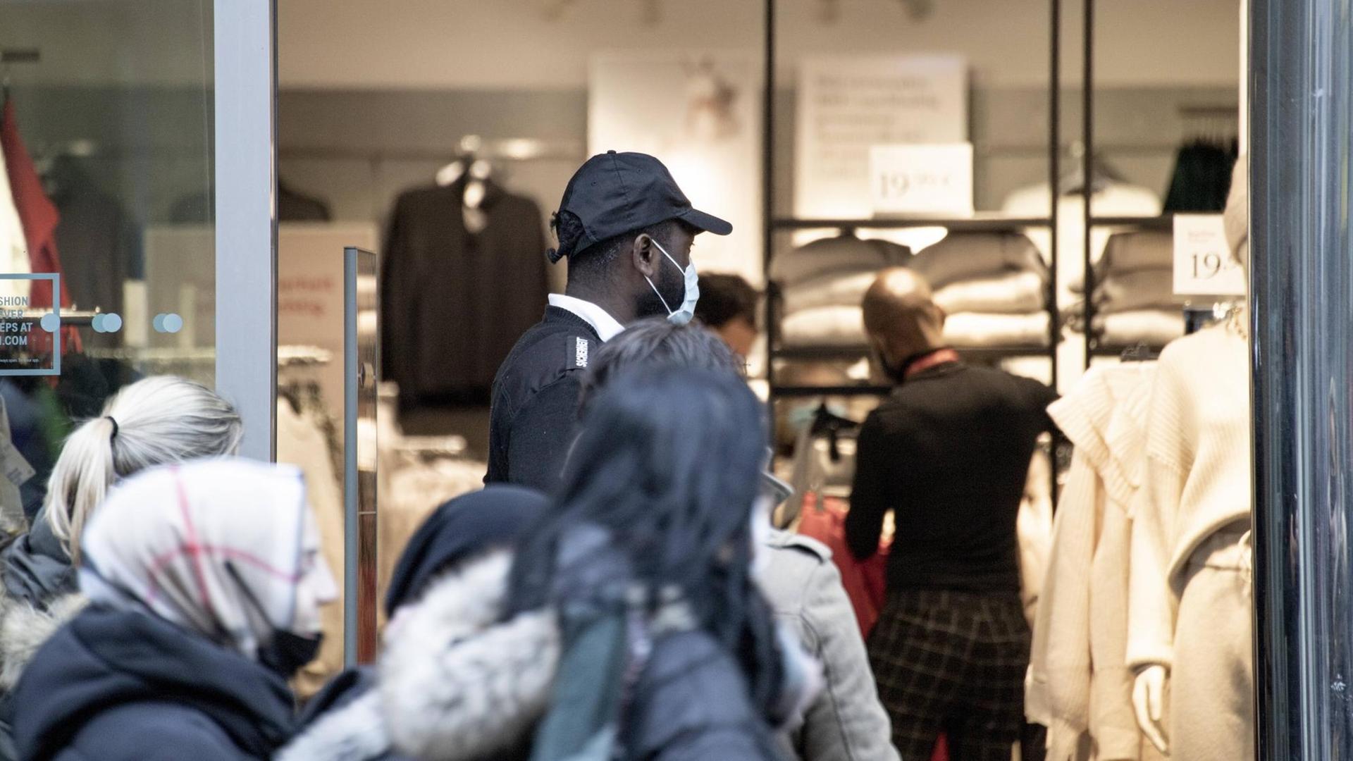 Warteschlange vor einem Kleidungsgeschäft in der Wiener Favoritenstraße, ein Security Mitarbeiter steht im Eingangsbereich, aufgenommen am 7. Dezember 2020. Warteschlange vor einem Kleidungsgeschäft in der Wiener Favoritenstraße, ein Security Mitarbeiter steht im Eingangsbereich, aufgenommen am 7. Dezember 2020.