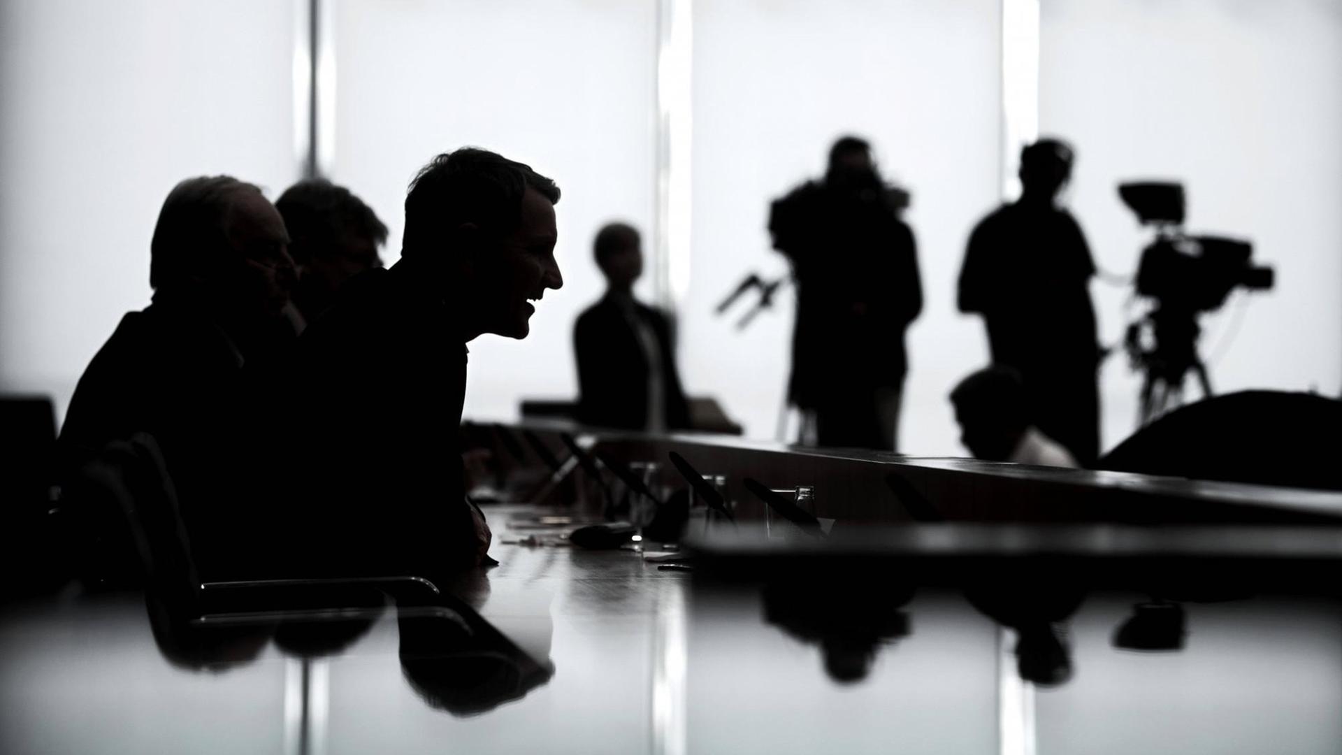 Silhouette von Björn Höcke bei einer Pressekonferenz der AfD nach der Landtagswahl in Thüringen. Im Hintergrund sind Silhouetten von Fernsehjournalisten mit Kamera zu sehen. Silhouette von Björn Höcke bei einer Pressekonferenz der AfD nach der Landtagswahl in Thüringen. Im Hintergrund sind Silhouetten von Fernsehjournalisten mit Kamera zu sehen.