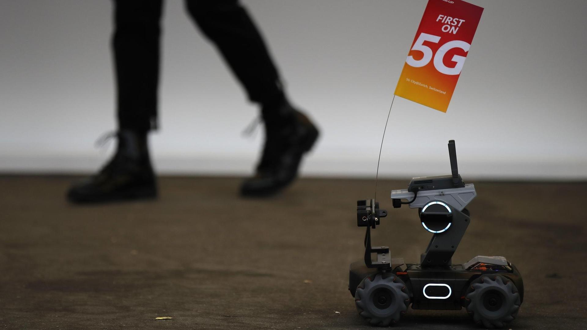 Eine 5G-Flagge, die von einem kleinen Fahrzeug-Roboter getragen wird, ist auf dem 10. Global Mobile Broadband-Forum abgebildet, das Huawei am 15. Oktober 2019 in Zürich veranstaltet. Eine 5G-Flagge, die von einem kleinen Fahrzeug-Roboter getragen wird, ist auf dem 10. Global Mobile Broadband-Forum abgebildet, das Huawei am 15. Oktober 2019 in Zürich veranstaltet.