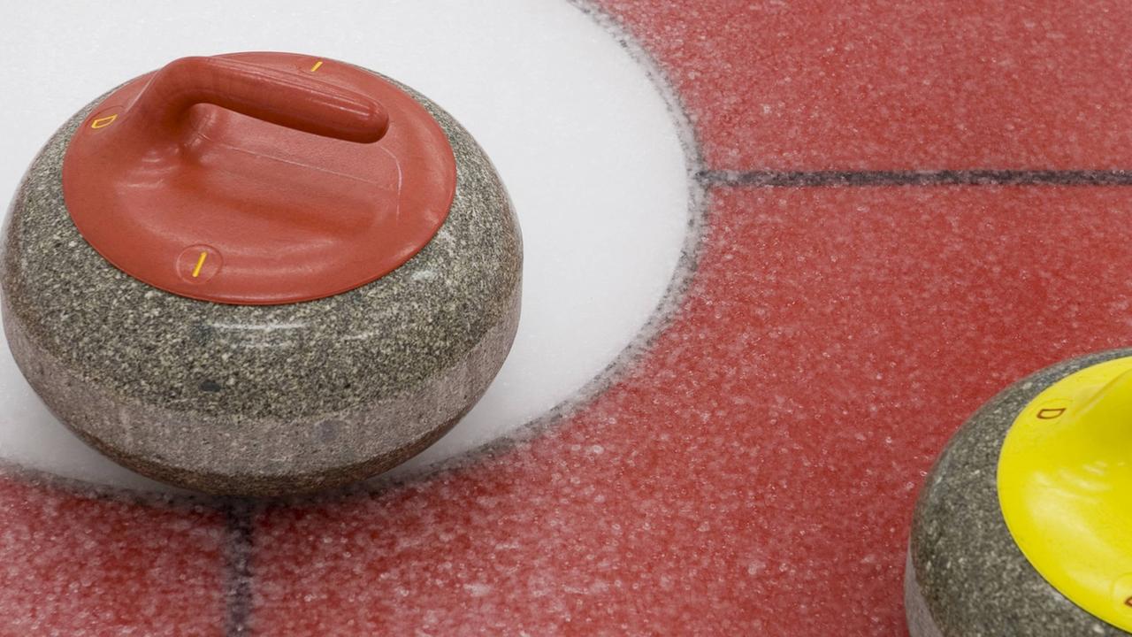 Curling rocks, die Spielsteine aus Granit, auf einer Spielfläche mit Eis.