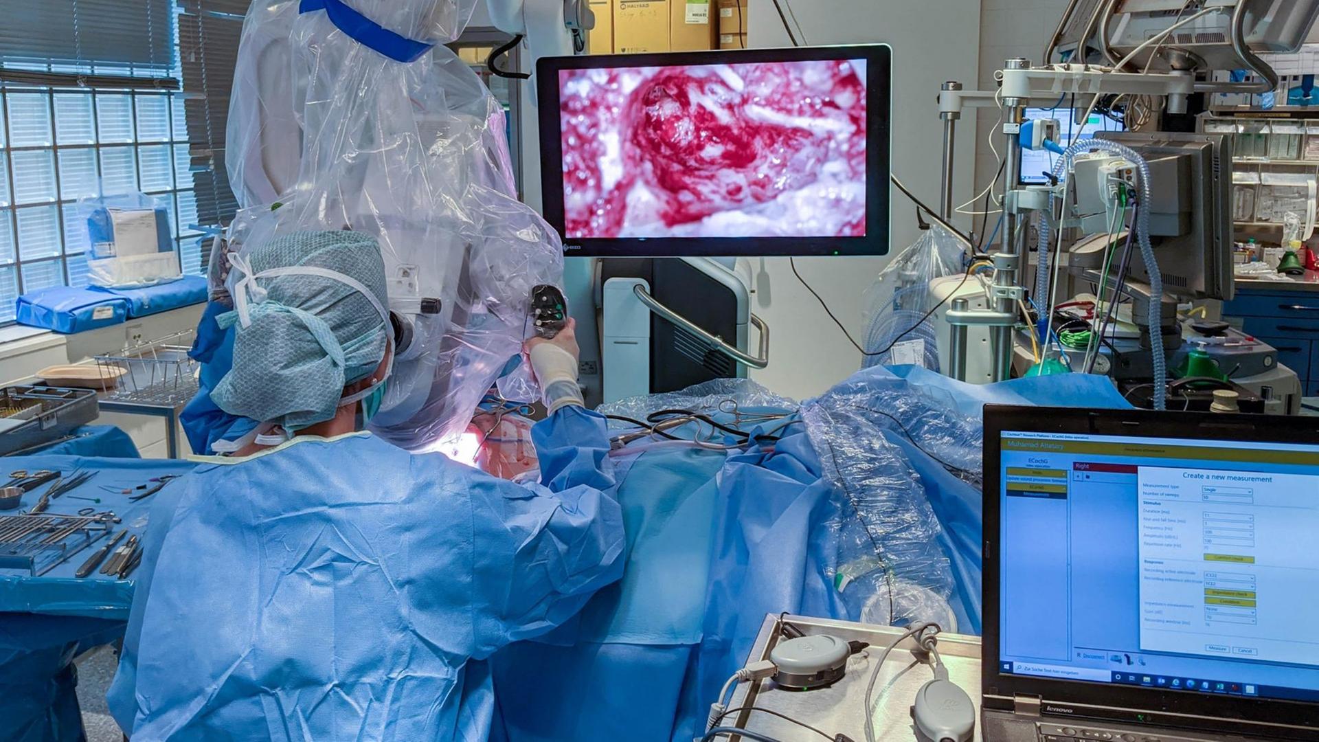 Operateurin im Operationssaal mit großem Monitor Operateurin im Operationssaal mit großem Monitor