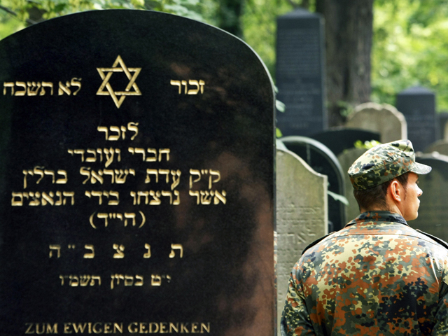 Ein Soldat der Bundeswehr neben einem Grabstein auf einem jüdischen Friedhof