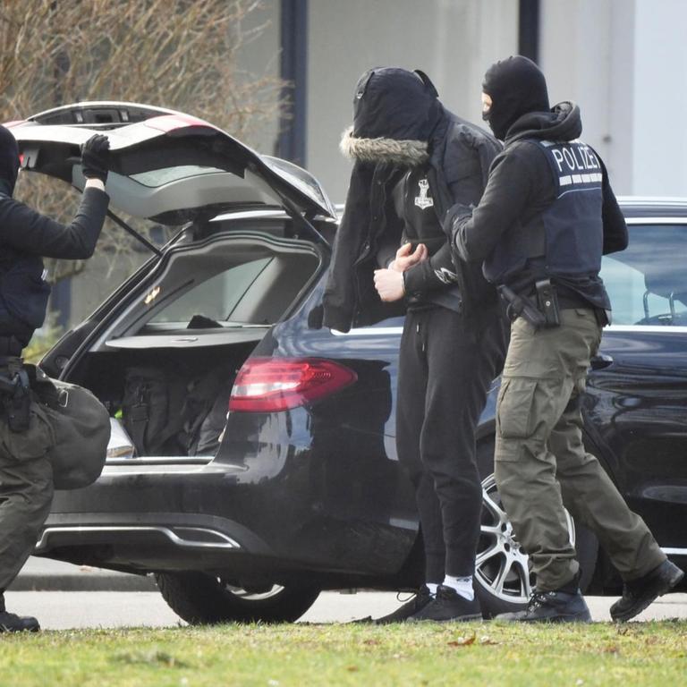 Eine Person wird von Polizisten in den Bundesgerichtshof gebracht.