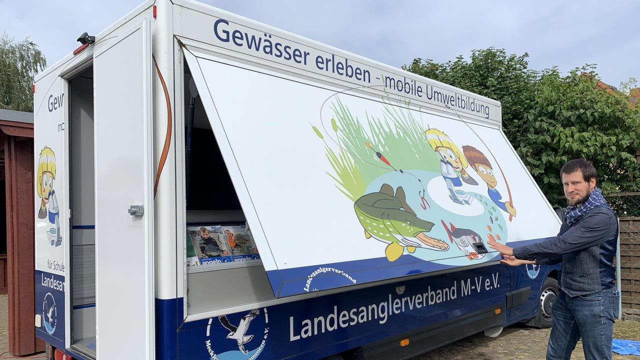 Das Bild zeigt das Infomobil des Anglerverbands. Christoph Witteck öffnet an der Seite eine Klappe, wie bei einem Verkaufswagen. Das Bild zeigt das Infomobil des Anglerverbands. Christoph Witteck öffnet an der Seite eine Klappe, wie bei einem Verkaufswagen.