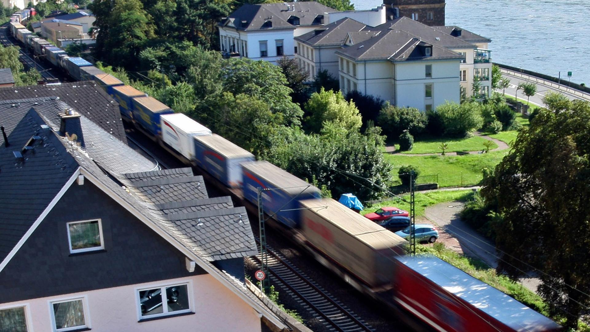 Ein Güterzug fährt an Häusern in Assmanshausen (Rüdesheim) vorbei Ein Güterzug fährt an Häusern in Assmanshausen (Rüdesheim) vorbei