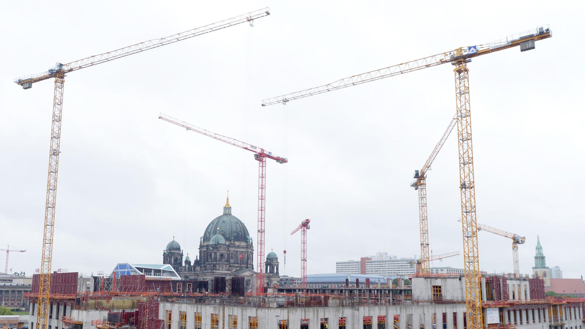 Kräne stehen auf der Baustelle des Berliner Schlosses - Humboldtforum in Berlin. Im Hintergrund ist der Berliner Dom zusehen. Kräne stehen auf der Baustelle des Berliner Schlosses - Humboldtforum in Berlin. Im Hintergrund ist der Berliner Dom zusehen.