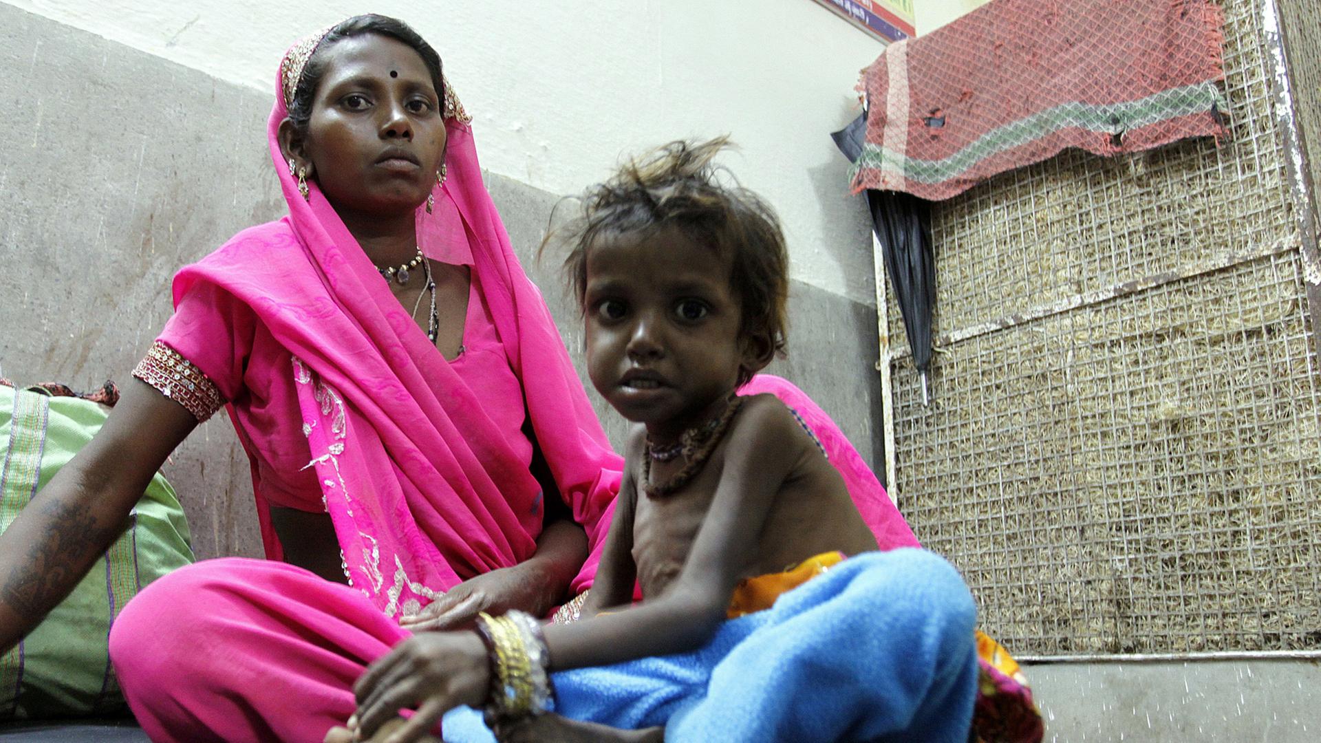 Eine Frau mit ihrem unterernährten Kind in einem Rehabilitationszentrum in Khalwa im indischen Madhya Pradesh Eine Frau mit ihrem unterernährten Kind in einem Rehabilitationszentrum in Khalwa im indischen Madhya Pradesh