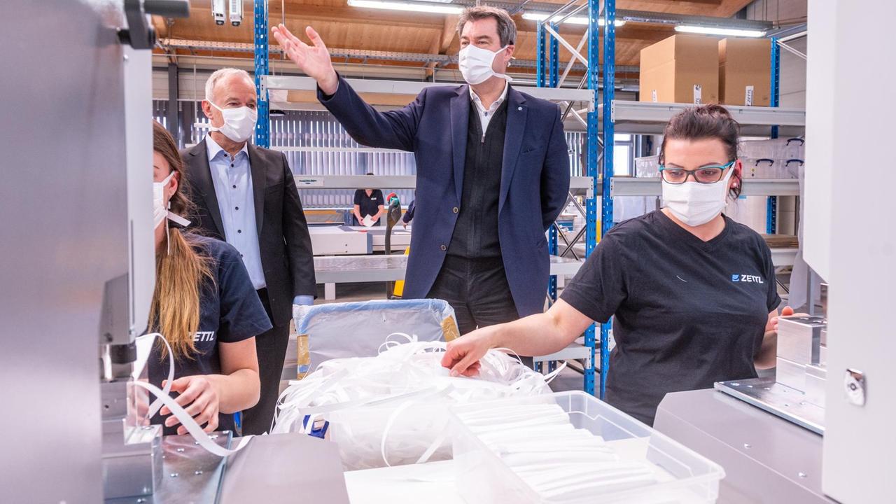 Markus Söder (CSU) steht mit einer Mundschutzmaske in einer Produktionshalle des Automobilzulieferers Zettl. Das Unternehmen hat angesichts der Corona-Krise seinen Betrieb auf die Produktion von Schutzmasken umgestellt. Markus Söder (CSU) steht mit einer Mundschutzmaske in einer Produktionshalle des Automobilzulieferers Zettl. Das Unternehmen hat angesichts der Corona-Krise seinen Betrieb auf die Produktion von Schutzmasken umgestellt.