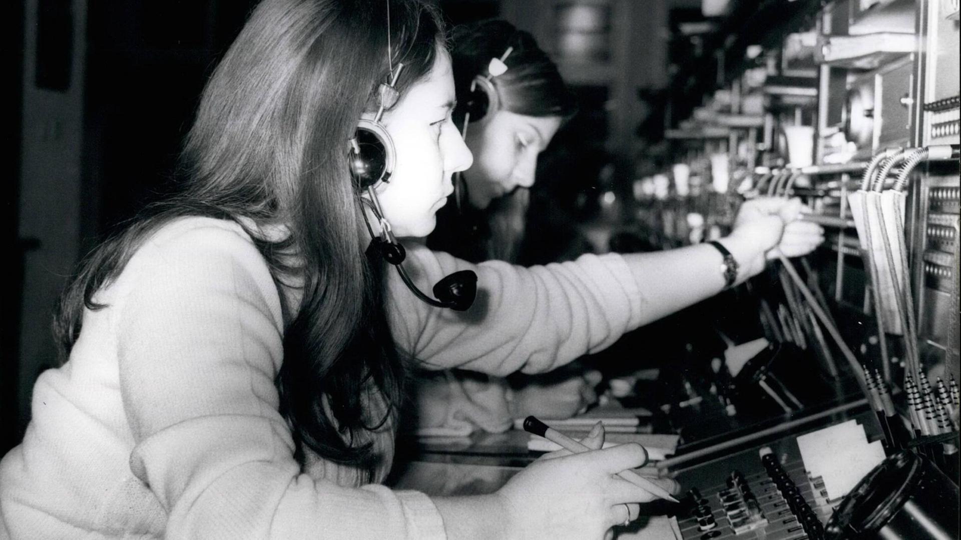 Schwarz-Weiß-Bild: Frauen stecken in Westberlin im Januar 1971 Kabel in Apparaturen, mit deren Hilfe man Telefonvebindungen herstellen kann. Schwarz-Weiß-Bild: Frauen stecken in Westberlin im Januar 1971 Kabel in Apparaturen, mit deren Hilfe man Telefonvebindungen herstellen kann.