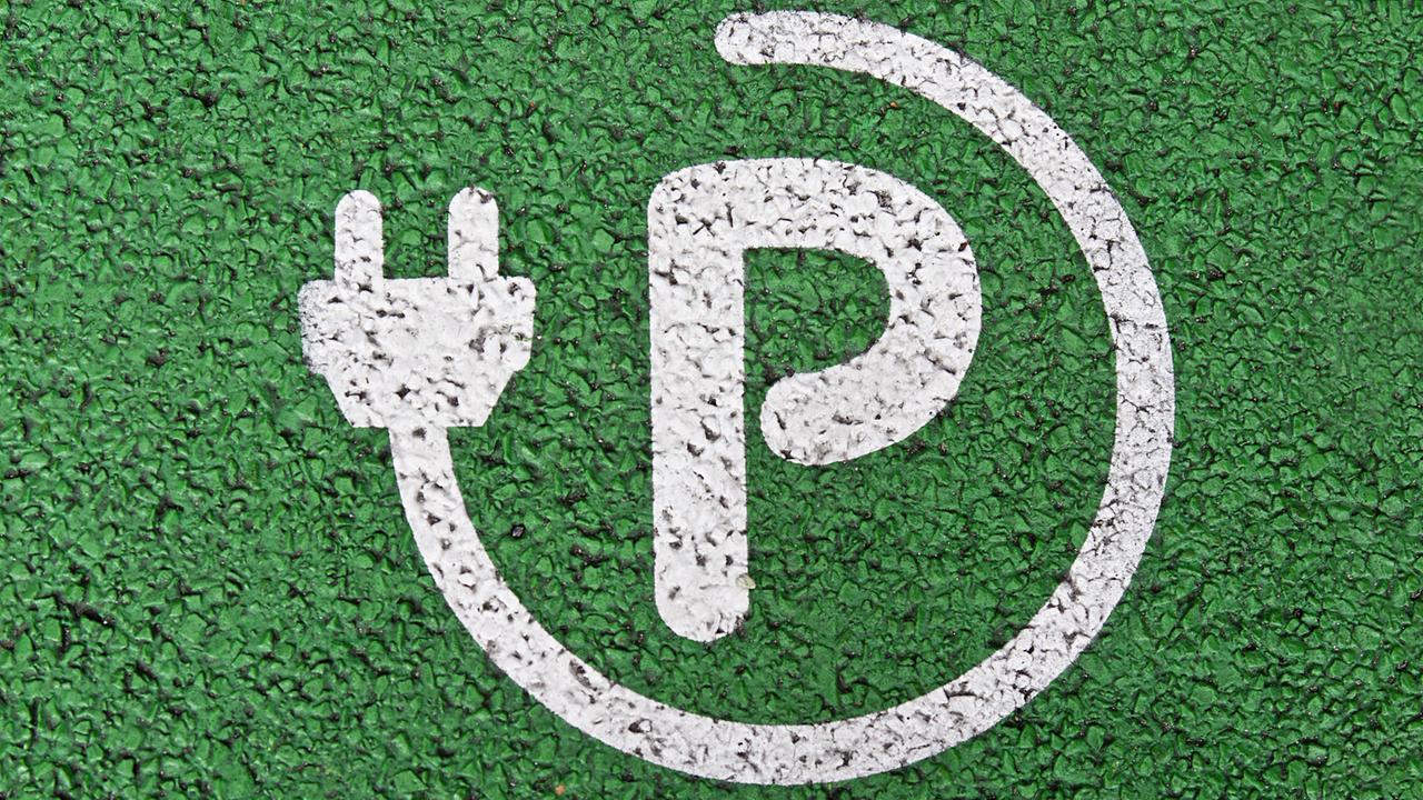 Ein weißes P, umrandet von einem Elektrokabel auf grünem Kunstrasen: Parkplatz vor einer Ladestation für Elektroautos in Berlin. Ein weißes P, umrandet von einem Elektrokabel auf grünem Kunstrasen: Parkplatz vor einer Ladestation für Elektroautos in Berlin.