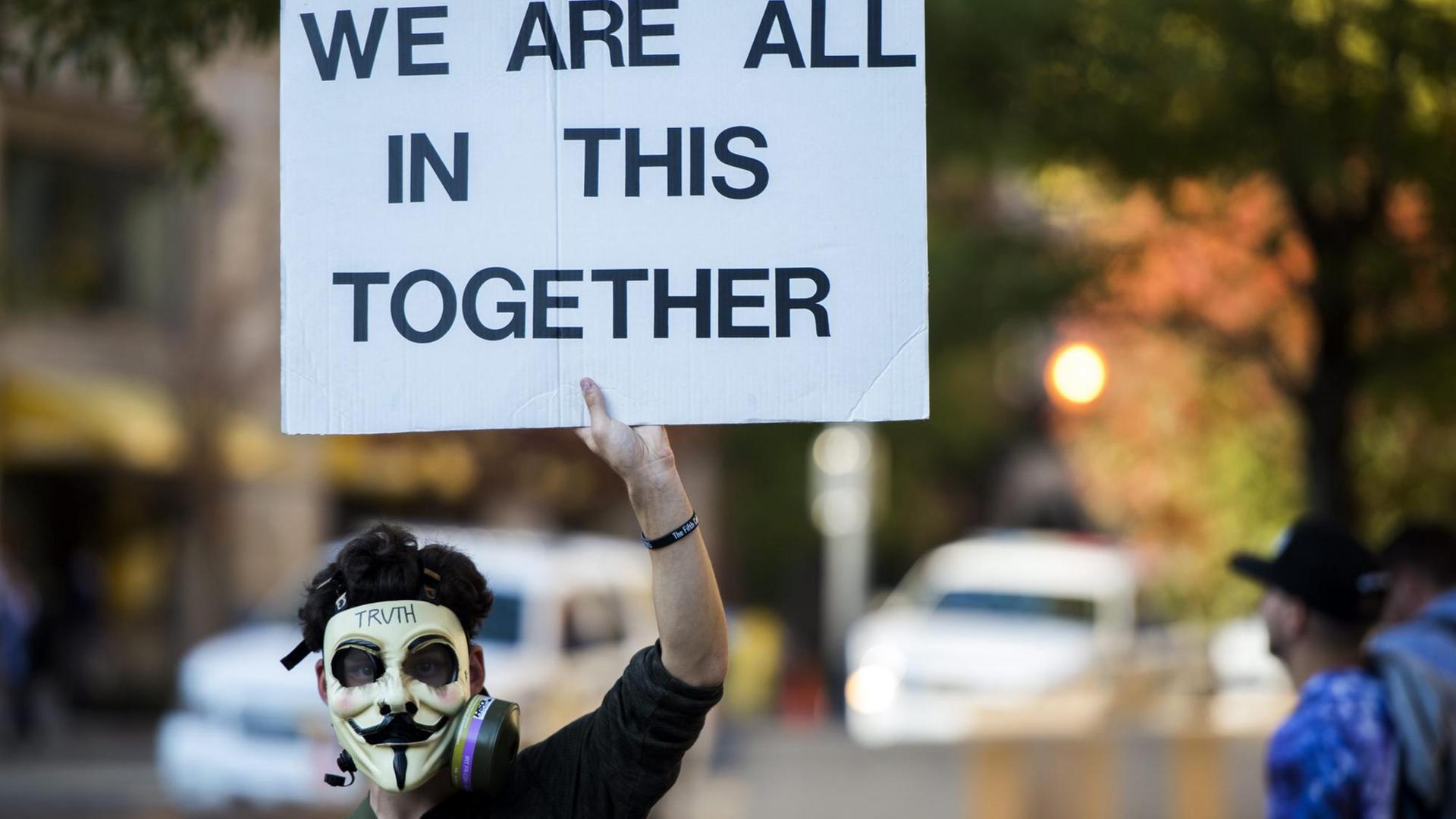 Ein Protestant mit einer Maske, die von Aktivisten der 'Anonymous'-Gruppe verwendet wird