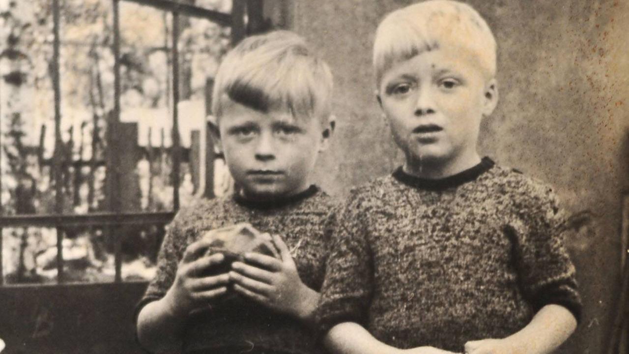 Eine alte Fotografie zweier Kinder. Eines hält einen Ball in der Hand. Eine alte Fotografie zweier Kinder. Eines hält einen Ball in der Hand.