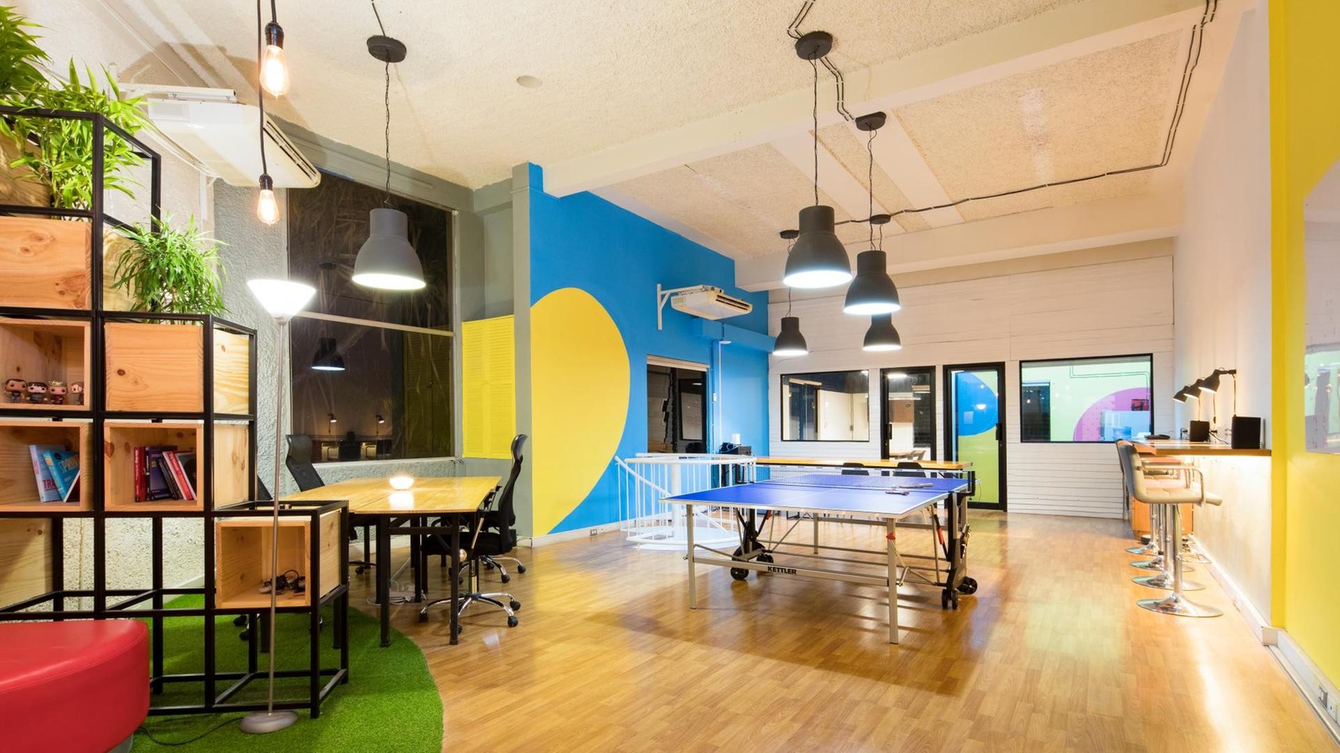 Aufnahme eines Startup-Büros. Mitten im Raum steht eine Tischtennisplatte. An der Seite Sitzgelegenheiten und eine Bar. Aufnahme eines Startup-Büros. Mitten im Raum steht eine Tischtennisplatte. An der Seite Sitzgelegenheiten und eine Bar.