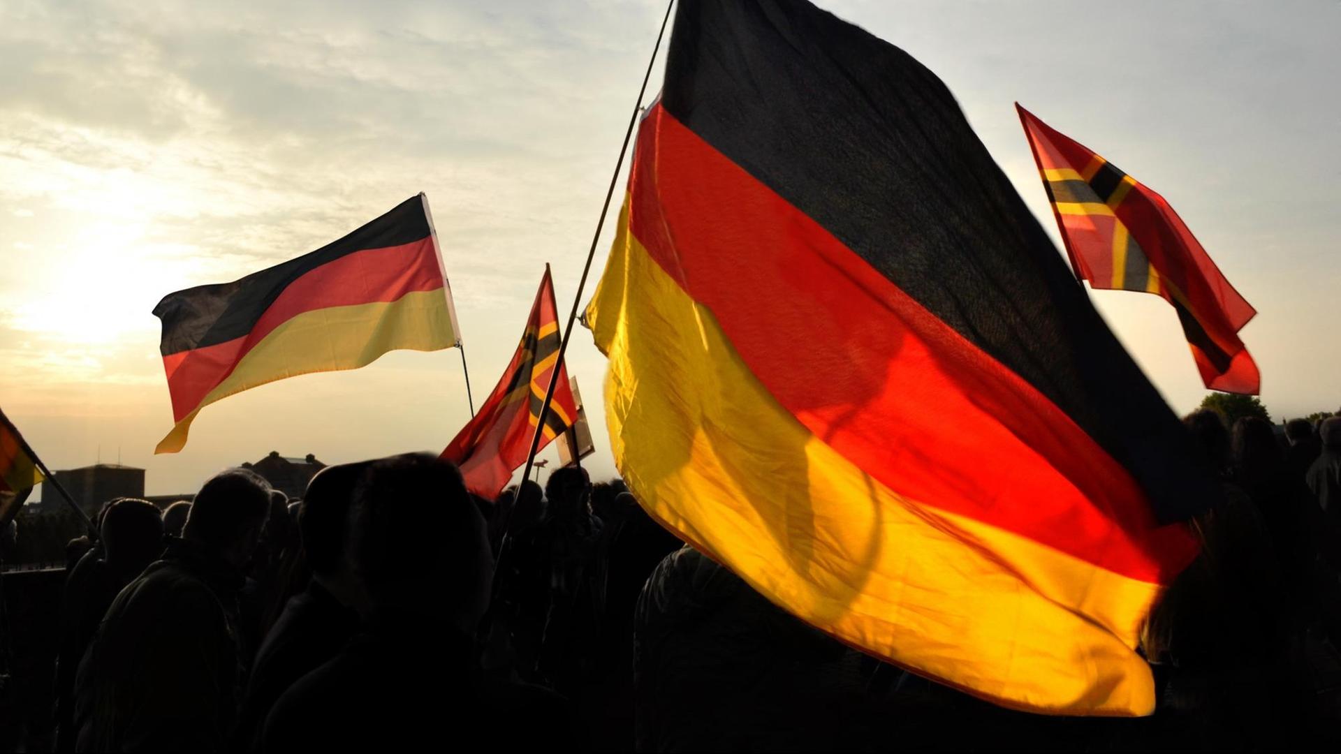 Deutschlandflaggen auf einer Demonstration neben Flaggen der rechten Reichsbürgerbewegung. Deutschlandflaggen auf einer Demonstration neben Flaggen der rechten Reichsbürgerbewegung.